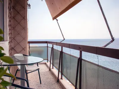 a balcony with a table and a view of the ocean at Above the Sea in Piraeus