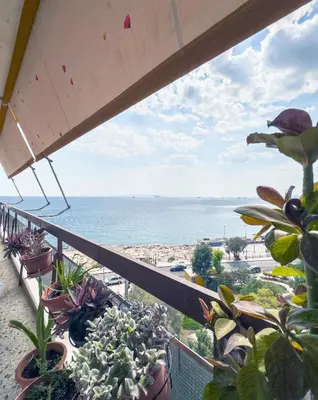 a balcony with potted plants and a view of the ocean at Above the Sea in Piraeus