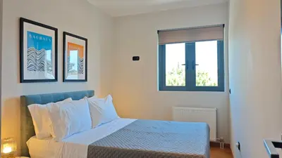 a bedroom with a bed and two pictures on the wall at Costa Voula Private Pool Penthouse by the Beach in Athens