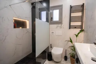 a white bathroom with a toilet and a sink at Mezcal Private Pool Villa in Kalívia Thorikoú