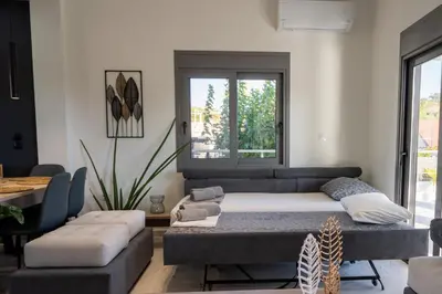 a living room with a bed and a couch at Mezcal Private Pool Villa in Kalívia Thorikoú