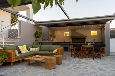 a living room with a green couch and a table at Mezcal Private Pool Villa in Kalívia Thorikoú