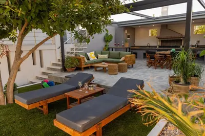 a patio with couches and tables and a bar at Mezcal Private Pool Villa in Kalívia Thorikoú