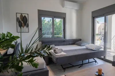 a living room with a couch and a large window at Mezcal Private Pool Villa in Kalívia Thorikoú