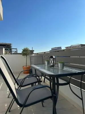 a table and chairs on top of a balcony at Parthenon view apt in Athens