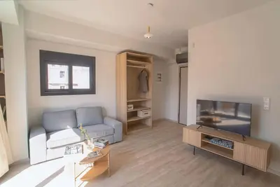 a living room with a couch and a tv at Parthenon view apt in Athens