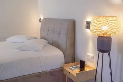 a bedroom with a bed and a table with a lamp at Parthenon view apt in Athens