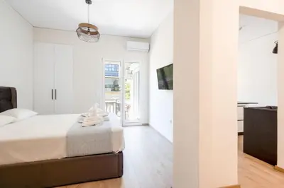 a white bedroom with a bed and a window at Elegance Suite Stunningly Renovated in Athens