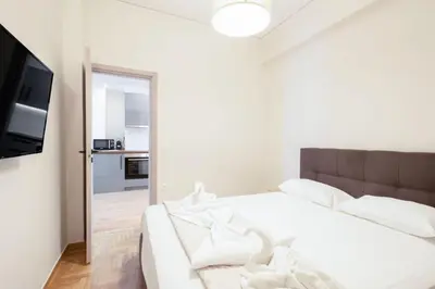 a bedroom with a white bed and a mirror at Spacious 3-Bedroom Dual Apartment in City Centre in Athens