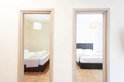 a bedroom with two beds and two mirrors at Spacious 3-Bedroom Dual Apartment in City Centre in Athens
