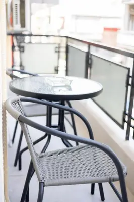 a table and chairs sitting on a balcony at Spacious 3-Bedroom Dual Apartment in City Centre in Athens
