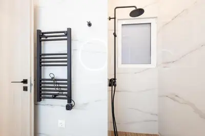 a shower in a bathroom with a mirror at Spacious 3-Bedroom Dual Apartment in City Centre in Athens
