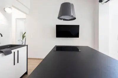 a kitchen with a black counter top and a tv at Spacious 3-Bedroom Dual Apartment in City Centre in Athens