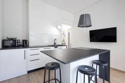 a kitchen with a black counter top and stools at Spacious 3-Bedroom Dual Apartment in City Centre in Athens
