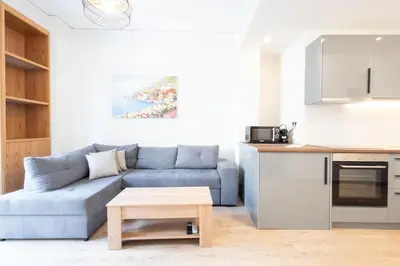 a living room with a blue couch and a table at Modern 2-Bedroom Gem close to Metro in Athens