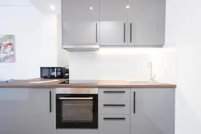 a kitchen with white cabinets and a counter top at Modern 2-Bedroom Gem close to Metro in Athens