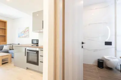 a kitchen and a living room with a door at Modern 2-Bedroom Gem close to Metro in Athens