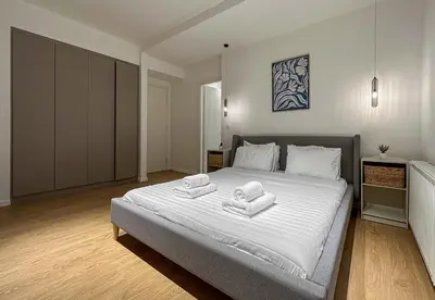 a bedroom with a large bed with towels on it at LIV - Modern Comfort Oasis in Pagrati in Athens
