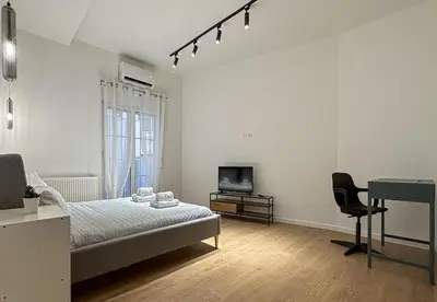 a bedroom with a bed and a television and a desk at LIV - Modern Comfort Oasis in Pagrati in Athens