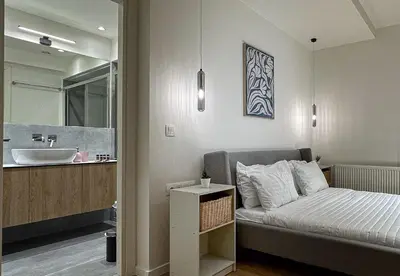 a small bedroom with a bed and a sink at LIV - Modern Comfort Oasis in Pagrati in Athens