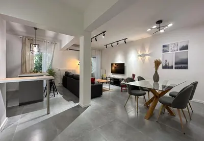 a living room and dining room with a table and chairs at LIV - Modern Comfort Oasis in Pagrati in Athens