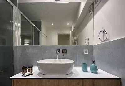 a bathroom with a sink and a large mirror at LIV - Modern Comfort Oasis in Pagrati in Athens