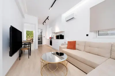 a white living room with a couch and a table at Stylish Apartment in Athens Riviera with Outdoor Patio in Athens