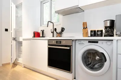 a white kitchen with a washing machine in it at Stylish Apartment in Athens Riviera with Outdoor Patio in Athens