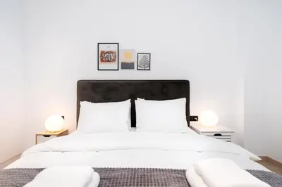a bedroom with a large white bed with two lamps at Stylish Apartment in Athens Riviera with Outdoor Patio in Athens