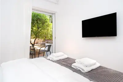 a bedroom with two beds and a flat screen tv at Stylish Apartment in Athens Riviera with Outdoor Patio in Athens