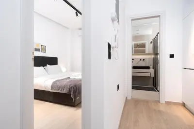 a white bedroom with a bed and a bathroom at Stylish Apartment in Athens Riviera with Outdoor Patio in Athens