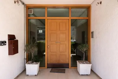 a wooden door of a building with two potted plants at Stylish Apartment in Athens Riviera with Outdoor Patio in Athens