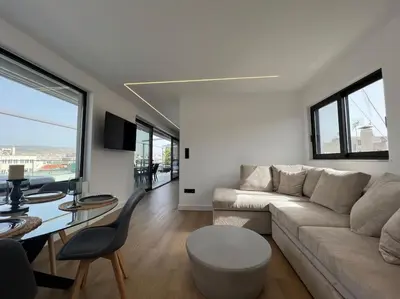 a living room with a couch and a table at BlueMotion - PortDome in Piraeus