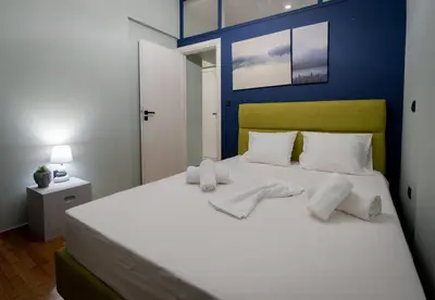 a bedroom with a large white bed with towels on it at LIV - Comfortable Designer Apt in Lycabettus in Athens