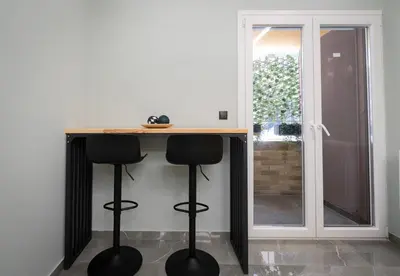 a kitchen with a counter with two stools under it at LIV - Comfortable Designer Apt in Lycabettus in Athens