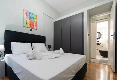 a bedroom with a large white bed with towels on it at LIV - Comfortable Designer Apt in Lycabettus in Athens