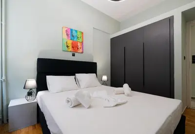 a bedroom with a white bed with towels on it at LIV - Comfortable Designer Apt in Lycabettus in Athens