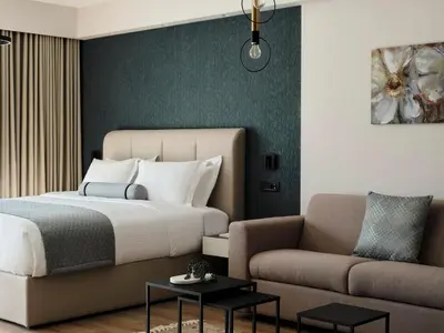 a bedroom with a bed and a couch at AVA Hotel & Residences Athens Riviera in Athens