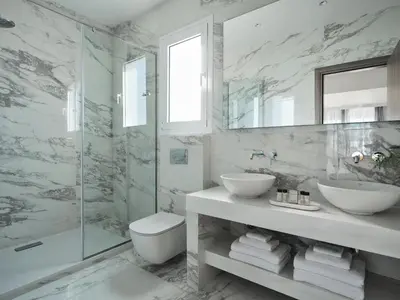 a bathroom with a sink and a glass shower at AVA Hotel & Residences Athens Riviera in Athens