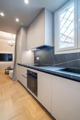 a kitchen with white cabinets and a window at Urban Elegance in Kolonaki in Athens