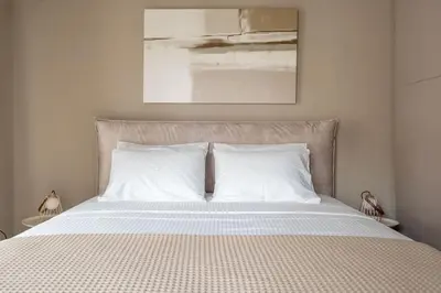 a bedroom with a bed with two pillows and a painting at Urban Elegance in Kolonaki in Athens