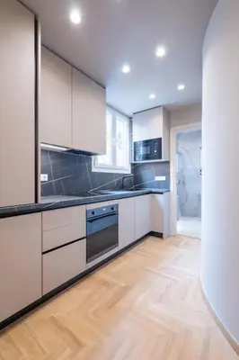 a kitchen with white cabinets and a wooden floor at Urban Elegance in Kolonaki in Athens