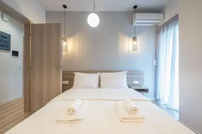 a bedroom with a large white bed with two towels at Superior Αpartment in Athens