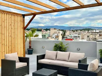 a patio with a couch and chairs on a balcony at Superior Αpartment in Athens