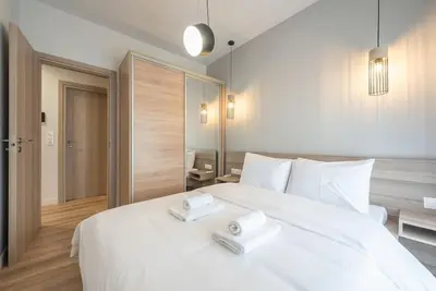 a bedroom with a large white bed with two towels on it at Superior Αpartment in Athens