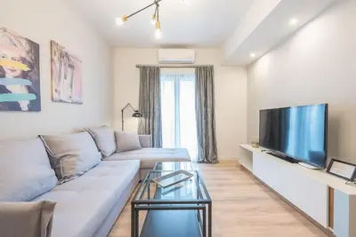 a living room with a couch and a flat screen tv at Superior Αpartment in Athens
