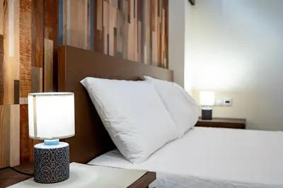 a bed with a pillow and a lamp on a table at Cozy Studio at Vyronas for 2 pers by MPS in Athens