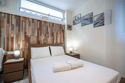 a bedroom with a large white bed with a window at Cozy Studio at Vyronas for 2 pers by MPS in Athens