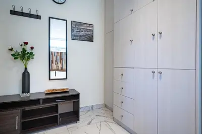 a room with white cabinets and a vase of flowers at Cozy Studio at Vyronas for 2 pers by MPS in Athens