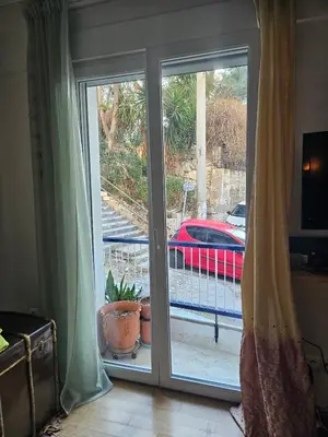 a sliding glass door with a view of a car at Urban by the Sea in Piraeus
